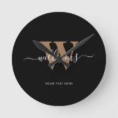 Modern Monogram Black Gold Script Initial Name Runde Wanduhr (Vorderseite)