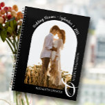 Moderne Foto Arch Black Wedding Planer<br><div class="desc">Ein eleganter spiralgebundener Planer mit 60 Seiten und 12 Monaten, mit einem Single vertikal oder portrait-orientiertes Hochzeitsfest-Foto in einem einzigartigen gewölbten Layout. WÄHLEN SIE EINE SOFT- ODER HARTDECKUNG AUS. Ihre Namen sind mit einem großen weißen Ampersand am unteren Ende verbunden und Ihr Hochzeitstermin oben gewölbt. Ändern Sie die Farbe der...</div>