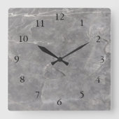 Moderne Uhr an der Wand aus grauem weißem Stein (Vorderseite)