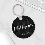 Modernes Personalisiertes Monogramm und Familienna Schlüsselanhänger<br><div class="desc">Personalisiertes Monogramm und Familiennamensgeschenk mit Familiennamen in weißem,  modernem Script Schriftart Stil und Monogramm in grauem,  modernem Script Schriftart Stil als Hintergrund mit festem Jahr in weißen Sans Serif Schriftart Stil auf schwarzem Hintergrund. Perfekt als Geschenk für Neuvermählte,  Familiengeschenk,  Familienspass und Wiedersehen für alle besondere Anlässe.</div>