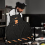 Monogram, eleganter Black-Gold-Name-Script-Koch Schürze<br><div class="desc">Mit Monogramm stilvolle und exklusive Küche Restaurant Master Koch Schürze mit einem Imitat vergoldeten Kupfer metallische Glitzer Quadrat und Linien auf einem stilvollen klassischen Imitat schwarzes Leder (PRINTED TEXTURE) Hintergrund.            Personalisiere ihn mit Titel,  Namen und Initialen.</div>