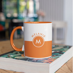 Monogramm auf weißem und orangefarbenem Trennbilds Tasse