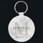 Monogramm und Name der personalisierten Bridesmaid Schlüsselanhänger<br><div class="desc">Fügen Sie Ihrer Hochzeit eine persönliche Touch mit dem Monogramm und dem Namensgeschenk der personalisierten Brautjungfrau hinzu. Dieses Design zeichnet sich durch den Namen der personalisierten Brautjungfrau aus, mit dem Titel und dem Hochzeitstag in Grau und Monogramm in hellgrau als Hintergrund, im klassischen Serif-Schriftart-Stil, auf weißem Marmorboden. Auch perfekt für...</div>