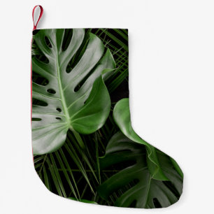 Monstera Blätter, luxuriöse tropische Anordnung. Kleiner Weihnachtsstrumpf