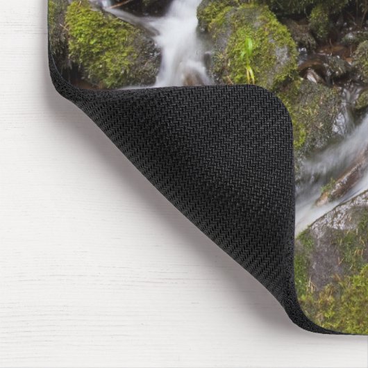 Moos bedeckte Felsen mit unscharfem Wasser und Mousepad (Ecke)