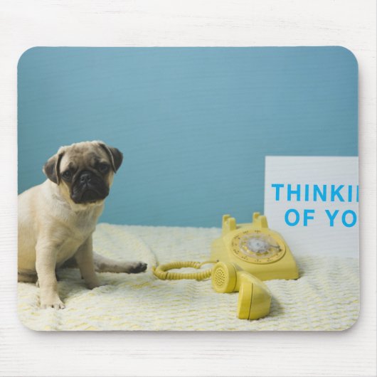 Mops Welpe sitzend auf dem Bett neben dem Telefon Mousepad (Vorne)
