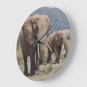 Mother elephant walking with elephant calf große wanduhr (Winkel)