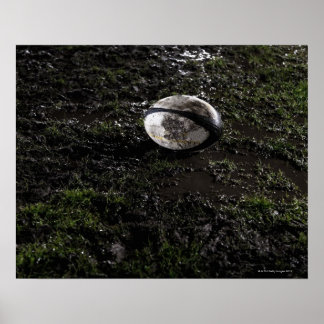 Muddy Rugby Ball sitzend auf einem zerkaut Gras Poster