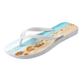 Muscheln, Seesternen und Kies auf einem Sandstrand Badesandalen (Schrägansicht)