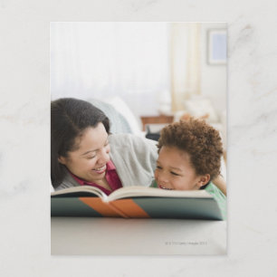 Mutter mit gemischtem Rennen liest Buch an Sohn Postkarte