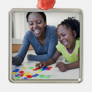 Mutter und Tochter, die mit Buchstaben spielen Ornament Aus Metall