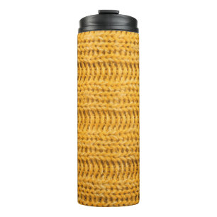 Nah aus gelbem gestricktem Hintergrund. Tr Thermosbecher