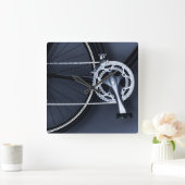 Nah oben von der Fahrradkette, -pedal und -gängen Quadratische Wanduhr (Zuhause)
