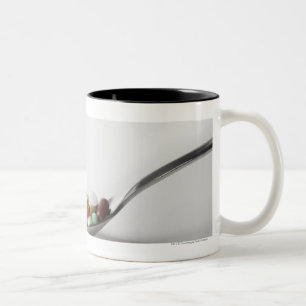 Nahaufnahme der Pillen in einem Löffel Zweifarbige Tasse