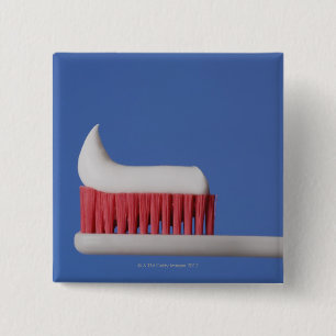 Nahaufnahme der Zahnpasta auf einer Zahnbürste Button