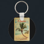 Nassau Palm Tree Vintage Travel Schlüsselanhänger<br><div class="desc">Ein einzigartiges Retrodesign aus der Mitte des Jahrhunderts im Stil eines Vintage-Reiseplakats. Es verfügt über eine geschwungene Palme am Sandstrand mit Ozean unter einem blauen bewölkten Himmel.</div>