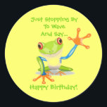 Niedlich Frog Funny Animal Kids Happy Birthday Runder Aufkleber<br><div class="desc">Niedlich Frog Funny Animal Kids Happy Geburtstagsticker. Klicken Sie auf die SCHALTFLÄCHE ANKUNFT,  um den Wortlaut zu ändern und die Größe an Ihre Bedürfnisse anzupassen. Dieser bunt grüne,  blaue und orangefarbene Cartoon Frosch winkt seiner großen Hand,  um Hallo und Glücklich zum Geburtstag zu sagen.</div>