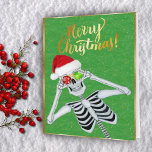 Niedlich Lächeln Skeleton Ornaments Weihnachtsmann Feiertagskarte<br><div class="desc">Diese Weihnachtsgrüßkarte hat ein niedliches Skelett,  das zwei glänzende Weihnachtsschmuck mit Schneeflocken in einer roten Weihnachtsmannmütze auf einem grünen Hintergrund mit Glitzern aus Imitat und einem goldenen Rahmen hält. Passen Sie den inneren Vers und Ihren Namen mit den Vorlagen an.</div>