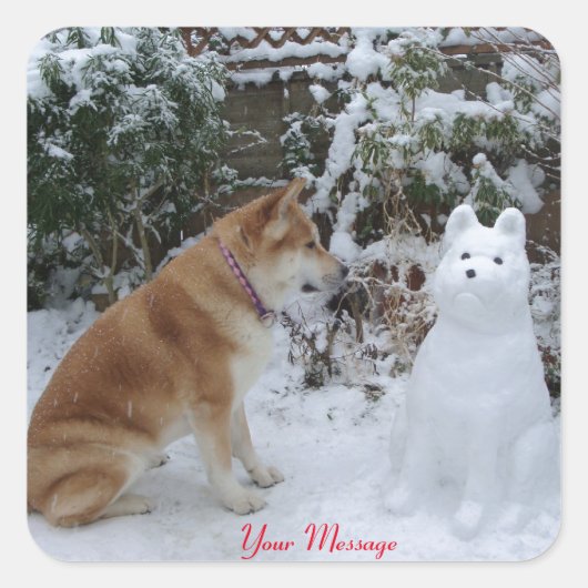 niedliche akita sitzt mit Schneemann im Schneehund Quadratischer Aufkleber (Vorderseite)
