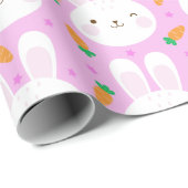 Niedliche Cartoonhäschen und -karotten auf rosa Geschenkpapier (Rolleneckpunkt)