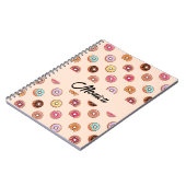 Niedliche dekorative Donuts auf rosa Notizblock (Linke Seite)