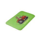 Niedliche glückliche Kuh, die einen roten Traktor- Badematte (Schrägansicht)