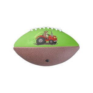 Niedliche glückliche Kuh, die einen roten Traktor- Football