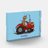 Niedliche glückliche Kuh, die einen roten Traktor- Fotoblock (Links)