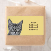 Niedliche Katze mit Brille auf dem gelben Adresset (Insitu)