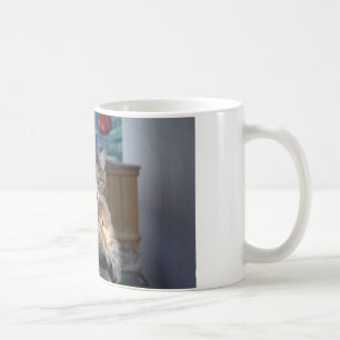 Niedliche Katze unterbrochen, während sie wächst Kaffeetasse