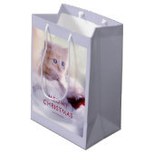 Niedliche Kittenruhe auf einer Weihnachtsmannmütze Mittlere Geschenktüte (Rückseite Schrägansicht)