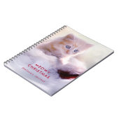 Niedliche Kittenruhe auf einer Weihnachtsmannmütze Notizblock (Linke Seite)