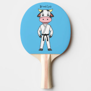 Niedliche Kuh in Kung Fu Anzug Cartoon Tischtennis Schläger