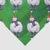 Niedliche Schafe in Weihnachtsmannmütze auf grün Seidenpapier (Ausschnitt)