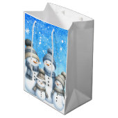 Niedliche Schneefamilie im Schnee Mittlere Geschenktüte (Vorderseite Schrägansicht)