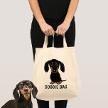 Niedliche Schwarz-und Tan-Dackel Dackel Dog Doggie Tragetasche<br><div class="desc">Ein bezaubernder, glatt gestrichener Schwarz-Weiß-Dackel-Welpe, der nach oben schaut. Der Text "Doggie Bag" kann mit Ihrem eigenen Namen oder Slogan personalisiert werden. Eine niedliche Dackel Hundesacktasche, ideal zum Shoppen von Lebensmitteln oder Haustierzubehör. Diese lustige Würstchen Hund Cartoon wiederverwendbare Tasche ist ein perfektes Geschenk für jeden, der einen Würstchen Liebe Hund....</div>