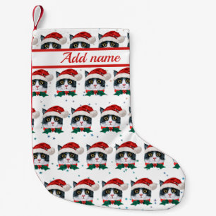 Niedliche Schwarz-Weiß-Katze mit Weihnachtsmannmüt Kleiner Weihnachtsstrumpf