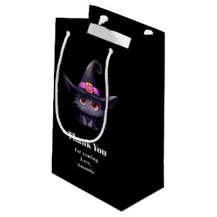Niedliche schwarze Katze, die einen Hexenhut trägt Kleine Geschenktüte