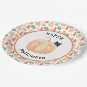 Niedliche schwarze Katze pinkelt über einem Kürbis Pappteller (Schrägansicht)