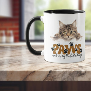 Niedliche Tabby Stripe Kitten Paws und genießen Si Tasse