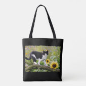 Niedliche Tuxedokatze auf einem Baumzweig mit Sonn Tasche (Rückseite)