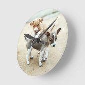 Niedliche Welpen spielen am Strand Runde Wanduhr (Winkel)