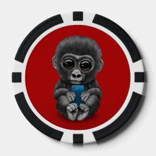 Niedlicher Baby-Gorilla, der ein Zellen-Telefon Pokerchips