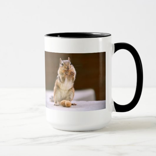 Niedlicher Chipmunk, der eine Erdnuss isst Tasse (Rechts)