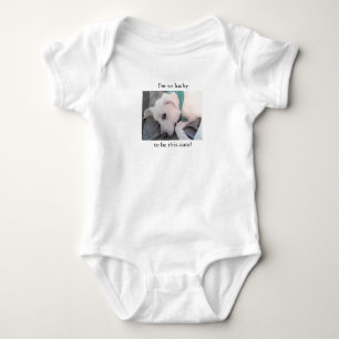 Niedlicher glücklicher weißer Welpenhund mit grüne Baby Strampler