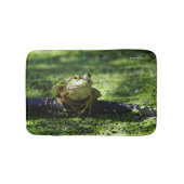 Niedlicher grüner Frosch schlägt eine Pose auf dem Badematte (Vorderseite)