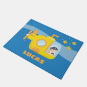 Niedlicher Junge im Unterseeboot scherzt Fußmatte (Schrägansicht)