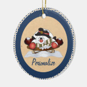 Niedlicher Schneemann auf einem Schlittelblauen Or Keramikornament (Links)