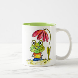 Niedlicher Whimsical Green Frosch unter einer rote Zweifarbige Tasse