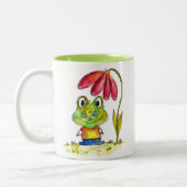 Niedlicher Whimsical Green Frosch unter einer rote Zweifarbige Tasse (Links)